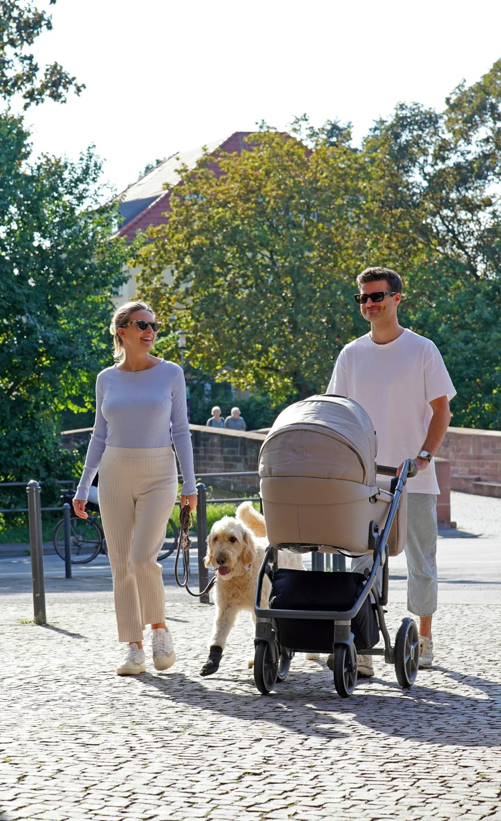 A family walking outdoors with a pram